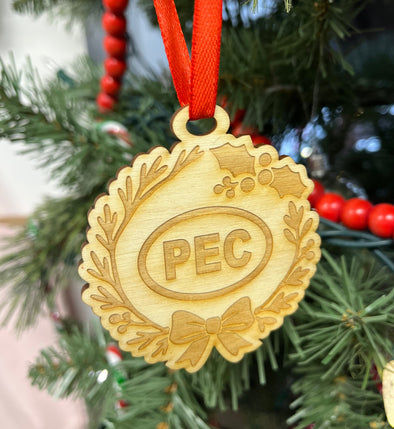 wood Christmas ornament with 'PEC' engraving on a tree